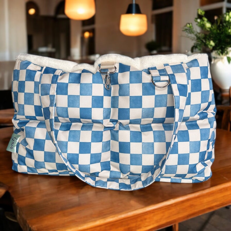May include: A blue and white checkered tote bag with a white sherpa lining and two handles. The bag is made of a quilted fabric and has a small tag that says "Linen".