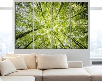May include: A multi-panel canvas print depicting a vibrant view looking up through a forest canopy. The image showcases tall, green trees with bright sunlight filtering through the leaves. The artwork is displayed above a cream-colored sofa.