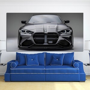 Puede incluir: Impresi&oacute;n en lienzo de un coche deportivo BMW gris, visto de frente. El coche tiene l&iacute;neas elegantes, una parrilla negra y faros brillantes. La impresi&oacute;n est&aacute; sobre un sof&aacute; azul con ribete blanco, con l&aacute;mparas.