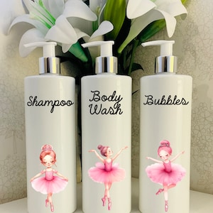 Puede incluir: Tres botellas blancas con bomba con ilustraciones de bailarinas y etiquetas que dicen "Champú", "Gel de Baño" y "Burbujas".