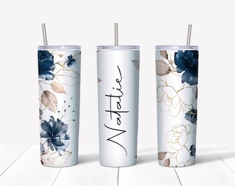 May include: Three stainless steel tumblers with a white background and a blue and gold floral design. The middle tumbler has the name "Natalie" written on it.