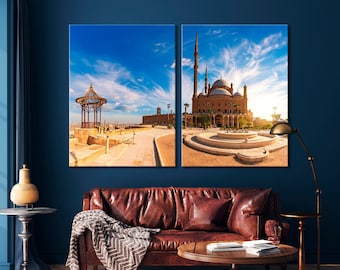 Könnte beinhalten: Ein geteilter Leinwanddruck mit einer Moschee mit einer großen Kuppel und Minaretten im Vordergrund und einem Pavillon im Hintergrund. Die Moschee ist aus rotem Backstein und hat eine weiße Kuppel. Der Pavillon ist aus Holz und hat ein weißes Dach. Der Himmel ist blau und es gibt Wolken am Himmel.