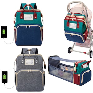 May include: Two different styles of nappy bags, one with a grey and green colour scheme and the other with a blue and green colour scheme. Both bags have a large main compartment and a smaller front pocket. The bags are shown with a pushchair and a baby bassinet.