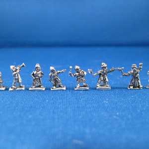 May include: A set of nine silver-colored miniature figures depicting various characters. The figures are standing on a blue surface and are all facing forward.