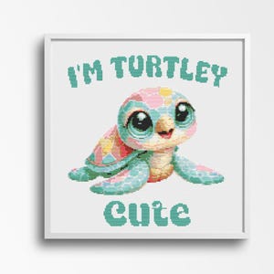 May include: A framed cross-stitch design featuring a cartoon sea turtle with large, expressive eyes. The turtle has a colorful shell with pink, yellow, and blue patterns. The text "I'M TURTLEY CUTE" is above and below the turtle in teal letters.