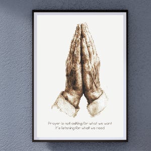 Op de afbeelding: Een ingelijst print met een tekening van twee handen die in gebed zijn gevouwen. De tekst onder de tekening luidt "Gebed is niet vragen om wat we willen, maar luisteren naar wat we nodig hebben."