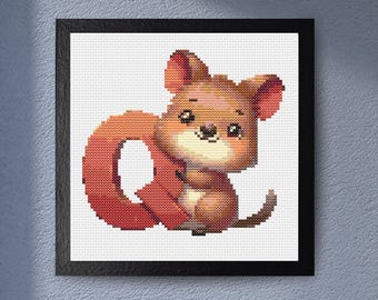 May include: A framed cross-stitch artwork featuring a cartoon-style animal, possibly a squirrel or a similar rodent. The animal is primarily brown with a red tail, set against a white background. The artwork is framed in a black square frame.
