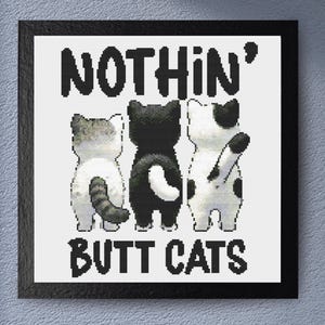 May include: A framed print featuring three pixelated cat rears. The cats are in black, white, and gray. The text above reads "NOTHIN'" and below "BUTT CATS" in bold, black letters. The artwork is set against a white background.