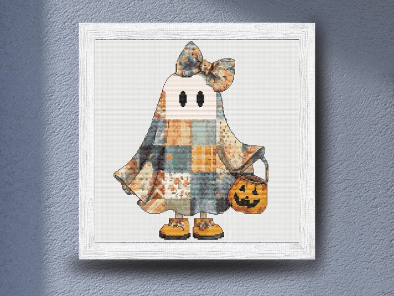 A delightful autumn cross stitch design of  a lovable ghost dressed in a patchwork Halloween costume filled with vintage-inspired quilt patterns and warm seasonal colors. The design combines soft creams, oranges, blues, and greys to create a comforting rustic aesthetic. Carrying a bright jack-o'-lantern bucket and wearing tiny yellow shoes, this character is ideal for Halloween decorating, cozy home decor, handmade seasonal gifts, and relaxing cross stitch projects for autumn enthusiasts.