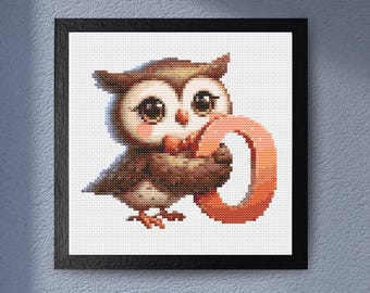 May include: Cross-stitch artwork of a charming owl holding an orange letter "O". The owl has brown and tan feathers, large eyes, and a pinkish-peach chest. The artwork is framed in a black square frame and mounted on a white background.