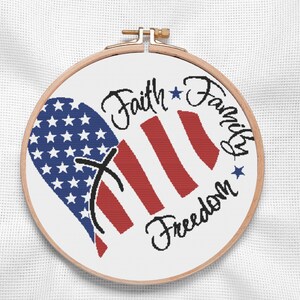Bold and modern cross stitch pattern featuring the American flag in a heart shape. Vivid navy stars and red stripes wrap around elegant hand-lettered script, ideal for Independence Day or military family gifts. Perfect for patriotic home decor with a personal handmade touch.