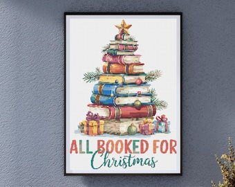 May include: A framed print featuring a Christmas tree made of stacked books. The books are various colors, with a gold star on top. The phrase "ALL BOOKED FOR Christmas" is written below the tree, with gift boxes at the base.