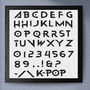 May include: Black framed print featuring a geometric font design. The print displays the alphabet, numbers, and symbols in a bold, black, pixelated style. The word "K-POP" is also included in the design.