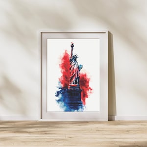 Peut inclure: Impression artistique encadrée représentant la Statue de la Liberté en aquarelle. L'œuvre utilise des teintes rouges, blanches et bleues pour créer un thème patriotique. La statue est centrée sur un fond blanc, encadrée d'un cadre blanc.