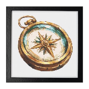 May include: Cross-stitch artwork of a vintage compass in a black frame. The compass features a gold-colored bezel, a white face with a star design, and a teal-colored ring. The artwork is detailed and appears to be hand-stitched.