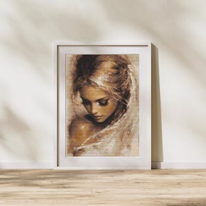 May include: A framed art print depicting a portrait of a woman with long, flowing blonde hair. The artwork uses soft, warm tones, highlighting the woman's face and delicate features. The print is presented in a white frame.