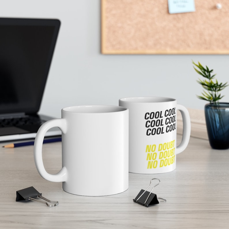 Peut inclure: Deux tasses en c&eacute;ramique blanche avec du texte noir et jaune. La tasse de droite a le texte "COOL COOL COOL COOL NO DOUBT NO DOUBT NO DOUBT".