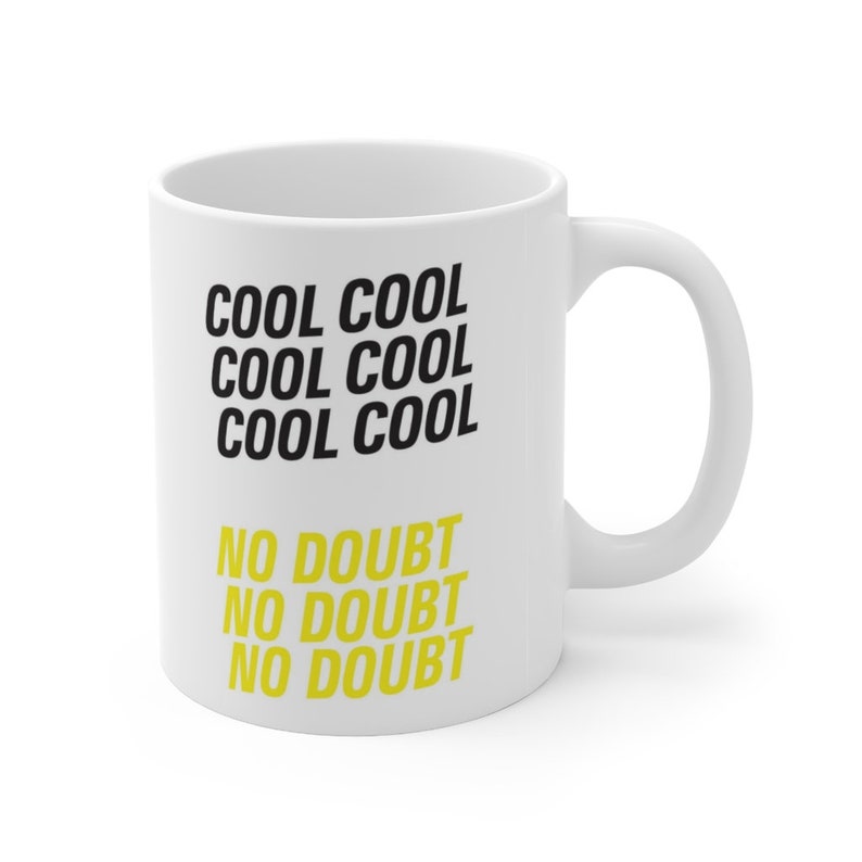 Peut inclure: Une tasse en c&eacute;ramique blanche avec du texte noir qui dit "Cool Cool Cool Cool Cool Cool" et du texte jaune qui dit "No Doubt No Doubt No Doubt"