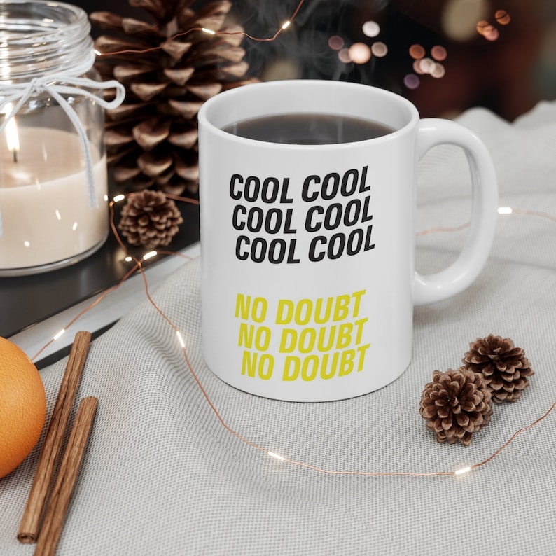Peut inclure: Une tasse &agrave; caf&eacute; en c&eacute;ramique blanche avec du texte noir qui dit "Cool Cool Cool Cool Cool No Doubt No Doubt No Doubt". Le texte "Cool Cool Cool Cool Cool" est dans une police plus grande que le texte "No Doubt No Doubt No Doubt".