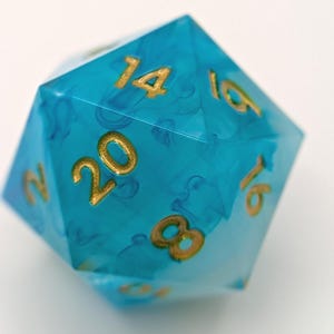 Swirly blue and white TTRPG dice with shiny amber inked numbers.