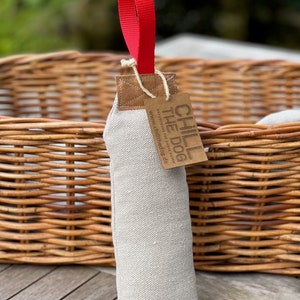 May include: A beige canvas dog toy with a red handle and a brown leather tag that says "CHILL THE DOG" with the website www.chillthedog.de.