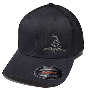 May include: A black and grey Flexfit baseball cap with a black mesh back. The cap features an embroidered image of a coiled snake with a 'Don't Tread On Me' inscription. The Flexfit logo is visible on the underside of the bill.
