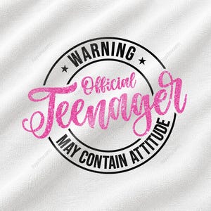 Könnte beinhalten: Ein weißer Stoffhintergrund mit einer kreisförmigen schwarzen Grafik mit dem Text WARNING, Official, Teenager und MAY CONTAIN ATTITUDE. Das Wort Teenager ist in einer großen, leuchtend pinken, glitzernden Schreibschrift mittig platziert.
