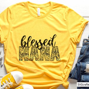 May include: Yellow t-shirt with a black and gold leopard print design that says "blessed nana".