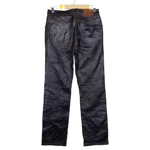 May include: Black, shiny pants with a straight leg design. The pants have two back pockets and a brown leather patch with the "Lee" logo. The pants are hanging on a wooden hanger.