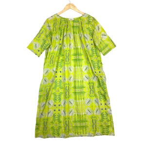 May include: A lime green midi dress featuring a repeating botanical pattern in white and dark blue. The garment has a round neckline with subtle pleating, short sleeves, and a loose, straight silhouette that falls below the knee on a hanger.