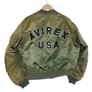 Puede incluir: Una taza de cer&aacute;mica blanca con asa negra y el texto "But First, Coffee" en negrita negra. La taza est&aacute; sobre una superficie blanca. La taza mide aproximadamente 10 cm de alto.