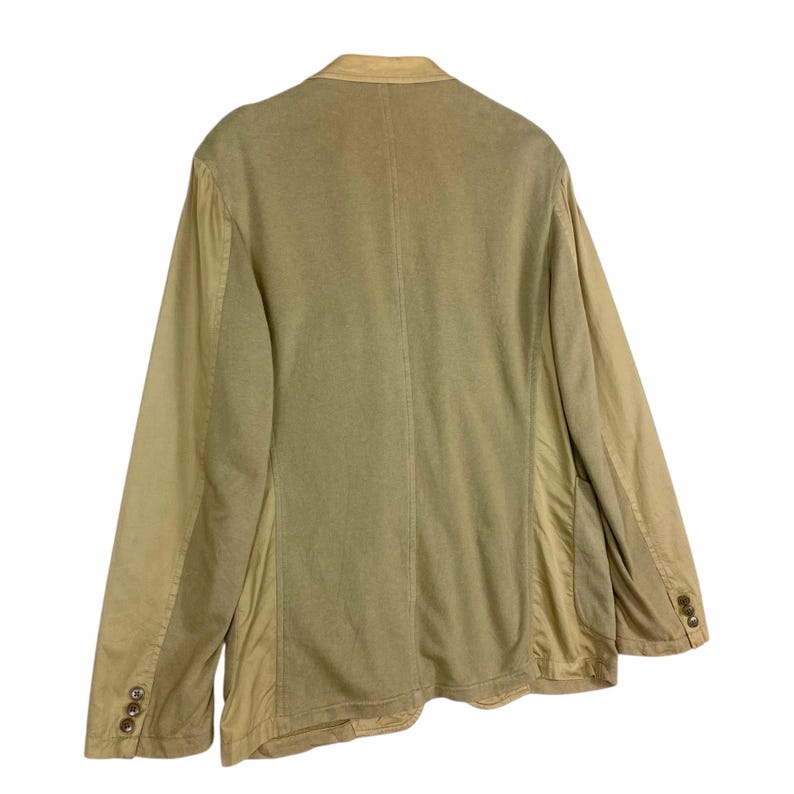May include: A tan blazer with a two-button closure and a notched lapel. The jacket has a contrasting fabric on the sleeves and side panels. The back of the blazer is visible, showcasing the tailored design and stitching details.