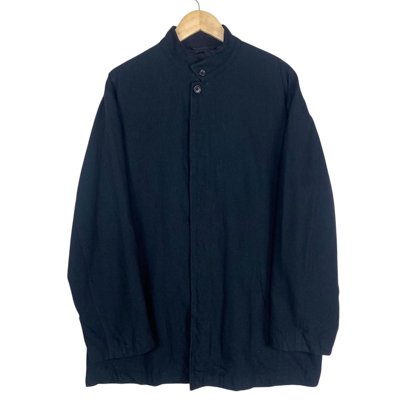 K&ouml;nnte beinhalten: Schwarze Jacke mit Stehkragen und Knopfverschluss. Die Jacke h&auml;ngt an einem Holzb&uuml;gel vor wei&szlig;em Hintergrund. Die lang&auml;rmlige Jacke scheint aus einem gewebten Stoff zu sein.