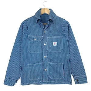 May include: Blue and white striped work jacket with four front pockets and a collared neckline. The jacket has a button-up closure and a small patch on the right chest. The jacket is hanging on a wooden hanger.