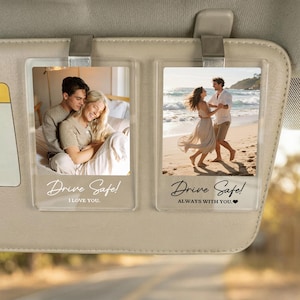 May include: Two rectangular clear acrylic car visor clips featuring custom photo prints. The left clip shows a couple embracing with the text Drive Safe! I LOVE YOU. The right clip shows a couple on a beach with the text Drive Safe! ALWAYS WITH YOU.