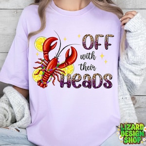 May include: Purple, white and leopard print graphic tee with a crawfish and lemons. The text on the shirt reads "Off with their heads."