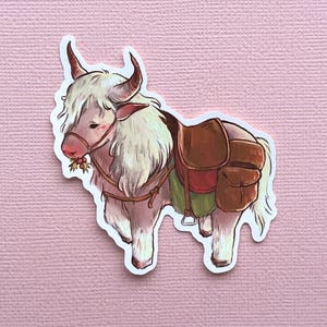 Puede incluir: Un yak blanco y peludo con una silla de montar marrón y una bolsa verde y roja atada a su espalda. El yak lleva una cabezada de cuero marrón y tiene una rama de acebo en la boca.