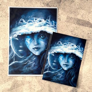 Può includere: Un dipinto ad acquerello blu e bianco di una donna con un velo. I suoi occhi sono chiusi e ha lacrime che le scorrono sulle guance. Lo sfondo è blu scuro.