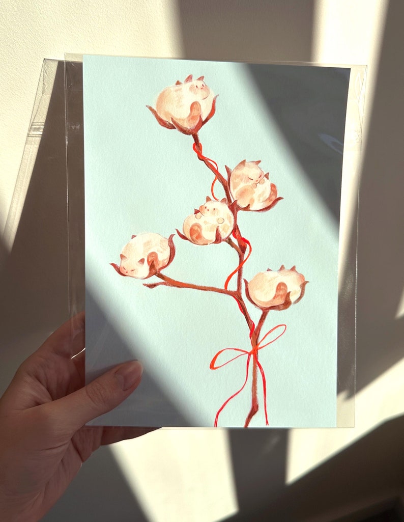 May include: A watercolor painting of a branch with five cotton balls, each with a small white cat sleeping inside. The branch is tied with a red ribbon.