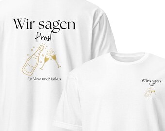 Op de afbeelding: Twee witte t-shirts met de tekst "Wir sagen Prost" en een gouden afbeelding van een champagnefles en glazen. De shirts hebben de tekst "für Alexa und Markus" op de achterkant.