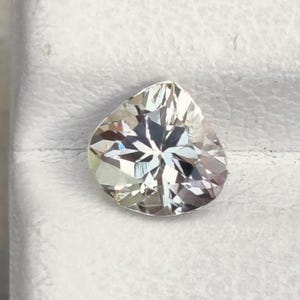 Tanzanita natural de color gris rosado, talla corazón, 5,9 x 5,7 mm, peso 0,70 ct, claridad de la piedra: limpia a simple vista. Gema suelta de tanzanita para joyería.