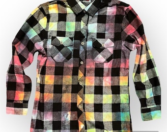 May include: A black and white plaid flannel shirt with a rainbow tie-dye effect. The shirt has long sleeves and a button-up front.