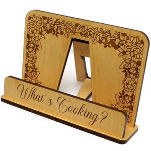Peut inclure: Un support de livre de cuisine en bois avec un motif floral et le texte "What's Cooking?" grav&eacute; sur le devant.
