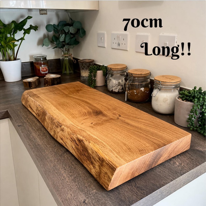 May include: A rectangular wooden chopping board, approximately 70cm long, with a natural edge. The board is made of light brown wood and sits on a dark countertop. The text "70cm Long!!" is visible in the image.