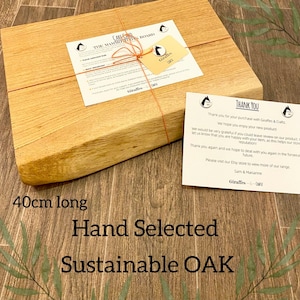 May include: A rectangular, hand-selected, sustainable oak cutting board, 40cm long, with a light brown finish. The board is wrapped with twine and includes a tag and a thank you note. The text on the board reads "Hand Selected Sustainable OAK".