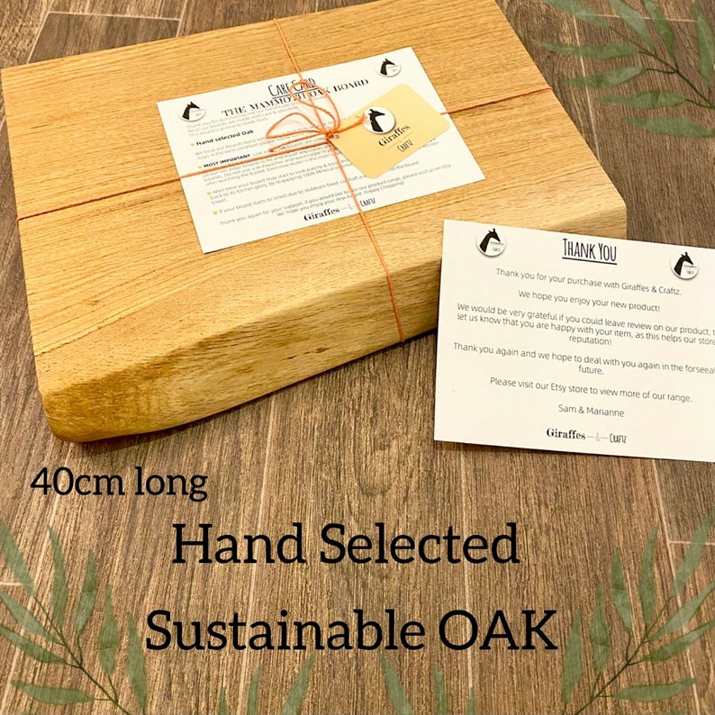 May include: A rectangular, hand-selected, sustainable oak cutting board, 40cm long, with a light brown finish. The board is wrapped with twine and includes a tag and a thank you note. The text on the board reads "Hand Selected Sustainable OAK".
