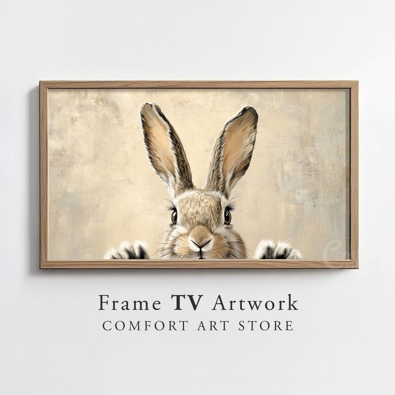 May include: A framed print of a brown rabbit with long ears peeking out from behind a beige background. The rabbit has a curious expression and its nose is twitching.