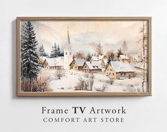 Op de afbeelding: Aquarel schilderij van een besneeuwd dorp met een kerktoren, omlijst in licht hout. Het kunstwerk toont een winterlandschap met besneeuwde daken en bomen. De tekst "Frame TV Artwork" en "COMFORT ART STORE" staat onderaan.
