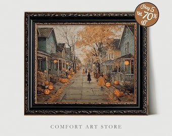 Puede incluir: Obra de arte enmarcada que representa una escena de Halloween. La imagen muestra una calle bordeada de casas, calabazas iluminadas y figuras disfrazadas. La obra de arte está en un marco negro con un borde decorativo. El texto "COMFORT ART STORE" está en la parte inferior.