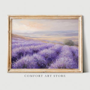 May include: A painting of a field of purple lavender flowers in a golden frame. The flowers are in the foreground with a distant view of rolling hills and a blue sky.